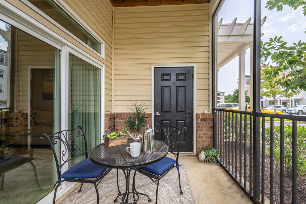 a patio with a table and chairs and a black door at Abberly Crest Apartment Homes, Lexington Park