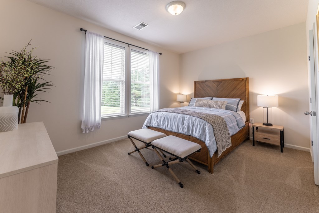 a bedroom with a bed and two windows at Abberly Crest Apartment Homes, Lexington Park, 20653