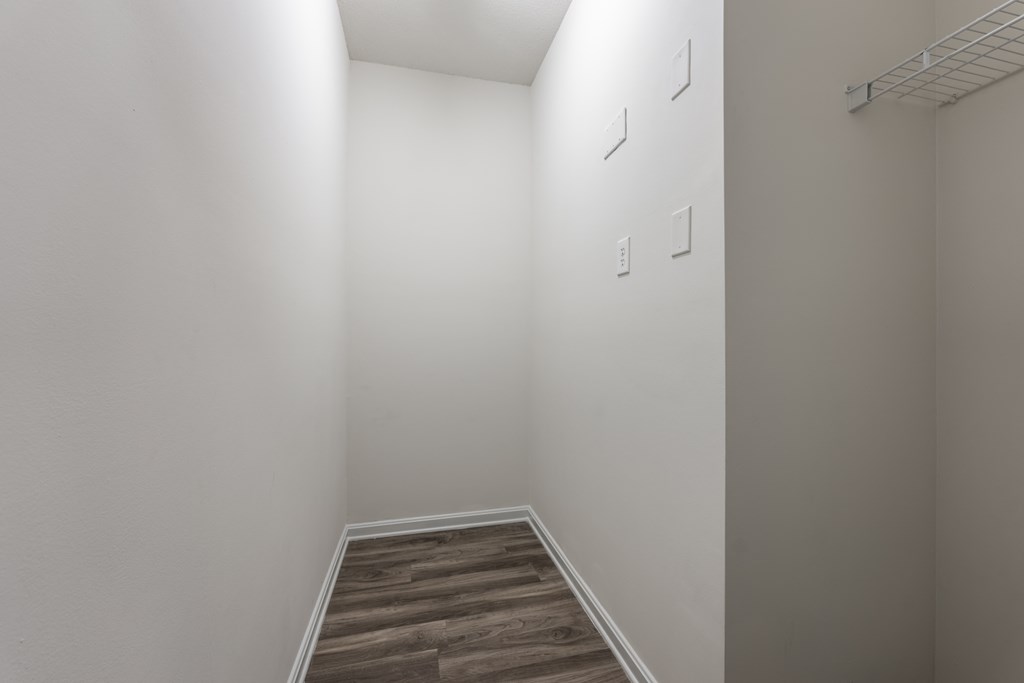 a bedroom with white walls and a wooden floor at Abberly Crest Apartment Homes, Lexington Park