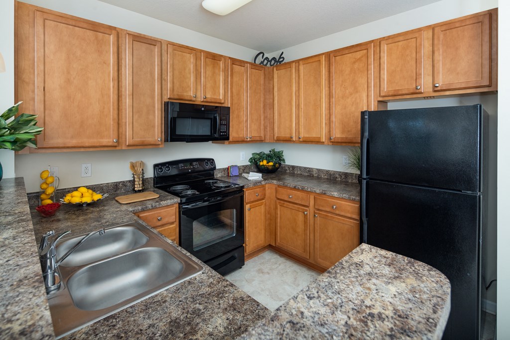 a kitchen with granite countertops and black appliances at Abberly Crest Apartment Homes, Lexington Park, 20653