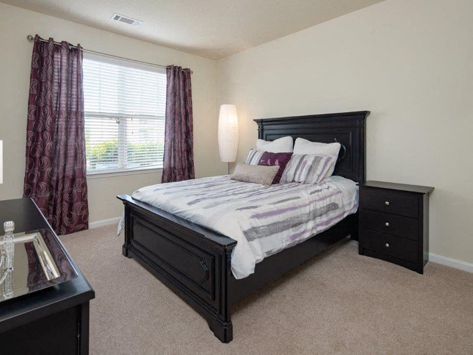 a bedroom with a bed and two night stands at Abberly Crest Apartment Homes, Maryland