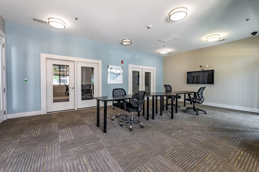 a conference room with a table and chairs and a tv on the wall at Abberly Crest Apartment Homes, Lexington Park, 20653
