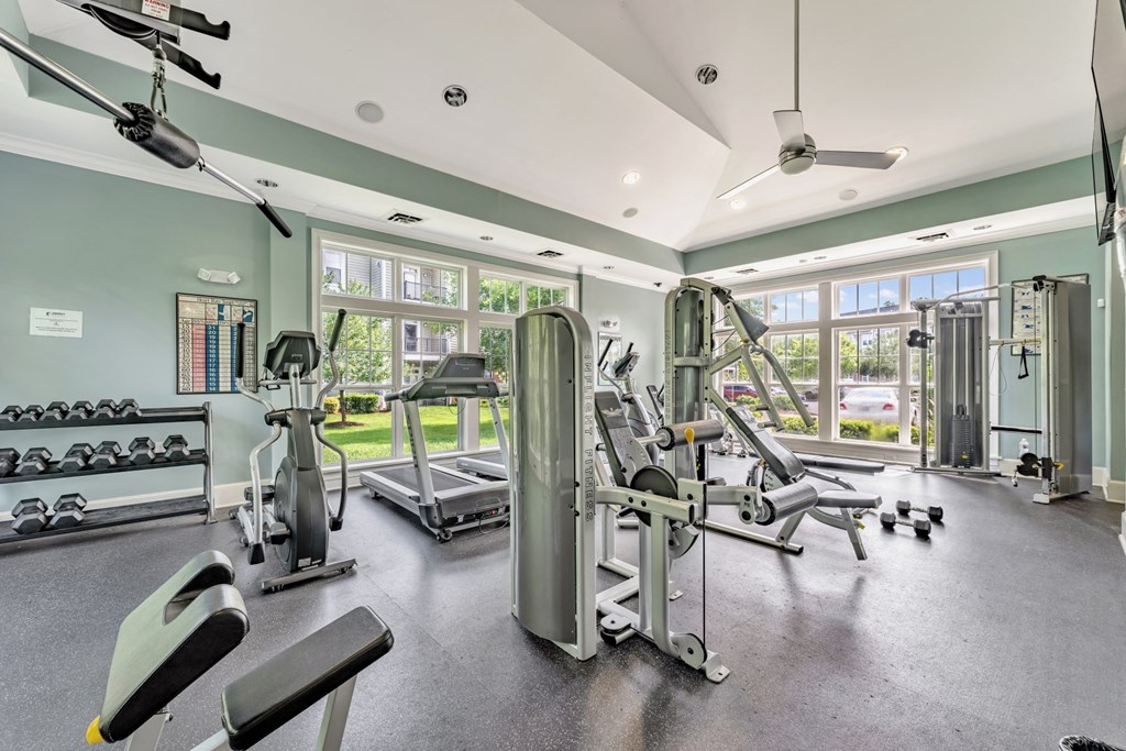 a gym with cardio equipment and windows at Abberly Crest Apartment Homes, Lexington Park, MD, 20653