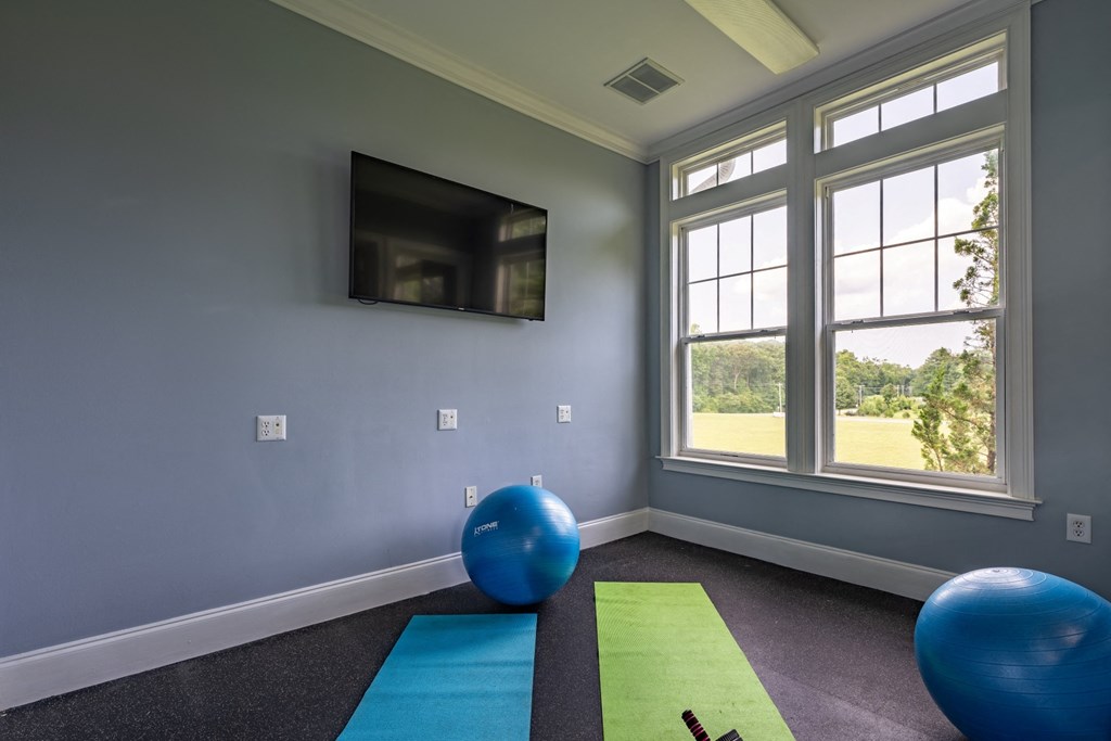 a yoga room with a tv and exercise balls at Abberly Crest Apartment Homes, Lexington Park