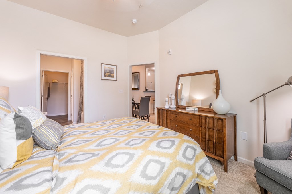 a bedroom with a bed and a dresser with a mirror at Abberly Crest Apartment Homes, Lexington Park, MD, 20653