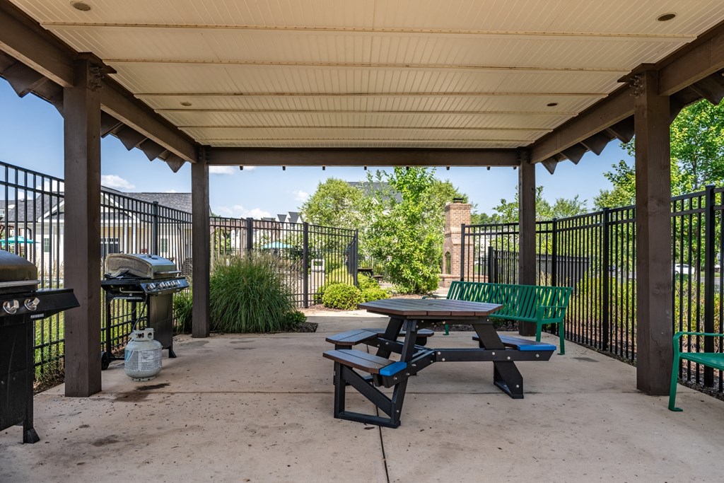 a picnic table and grill at the whispering winds apartments in pearland, tx  at Abberly Crest Apartment Homes, Lexington Park, MD