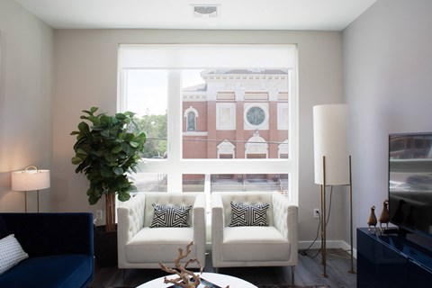 A living room with a white couch and a large window.