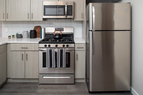 A modern kitchen with a stainless steel refrigerator and stove.