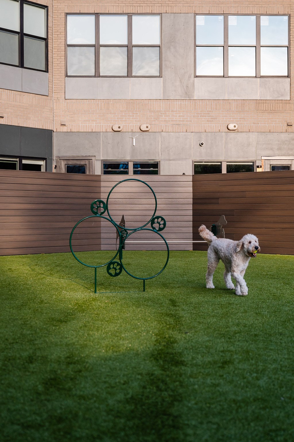 a dog standing next to a sculpture on a lawn