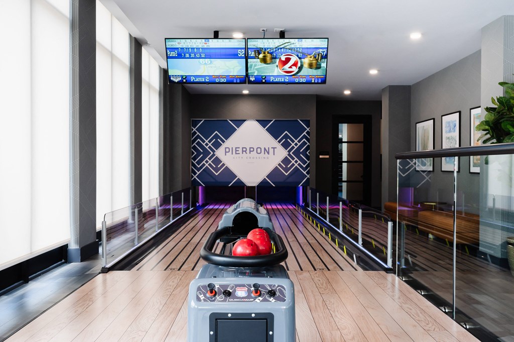 a bowling alley with a projector screen and a bowling ball in front of a bowling