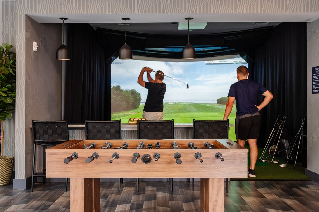 two men playing a game of golf on a large screen tv in a game room