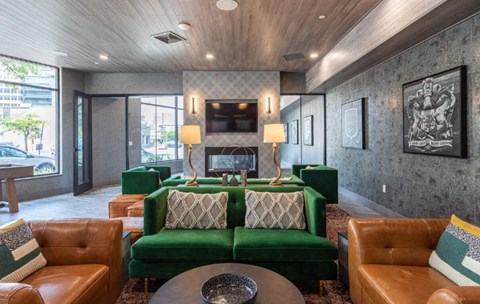 A living room with a green couch and brown leather chairs.