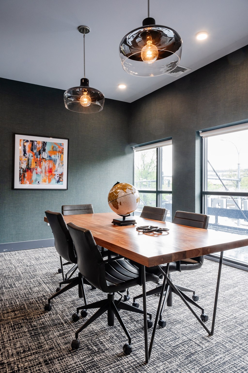 a conference room with a wooden table and black chairs