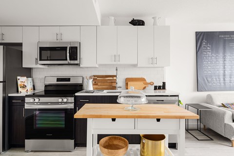 a kitchen with white cabinets and black appliances