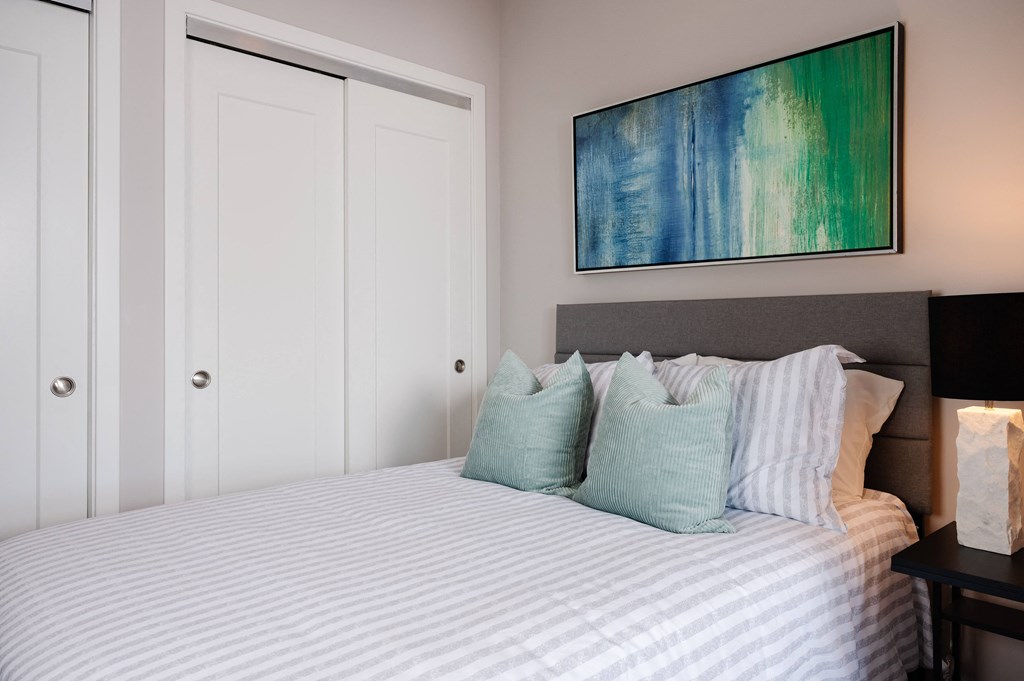 a bedroom with a bed and a painting on the wall