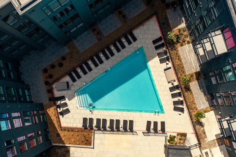 A swimming pool surrounded by black lounge chairs.