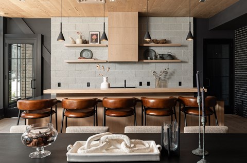 A modern kitchen with a long table and chairs.