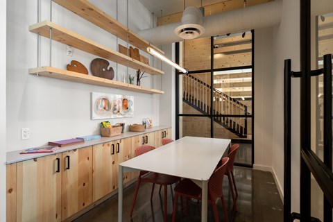 A kitchen with wooden cabinets and a white table.