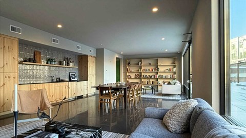 A modern living room with a kitchen area in the background.