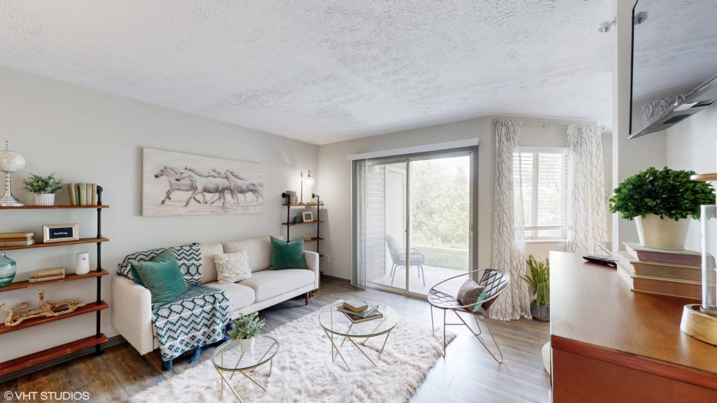 a living room with a white couch and a sliding glass door at Runaway Bay Apartments, Columbus, OH, 43204