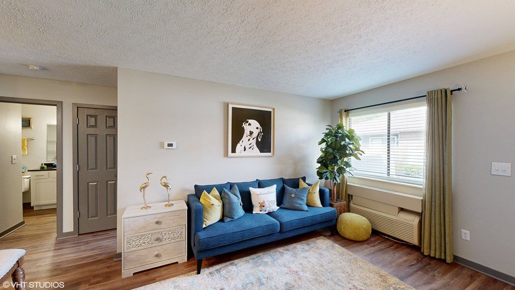 a living room with a blue couch and a window at Springburne at Polaris Apartments, Columbus, OH