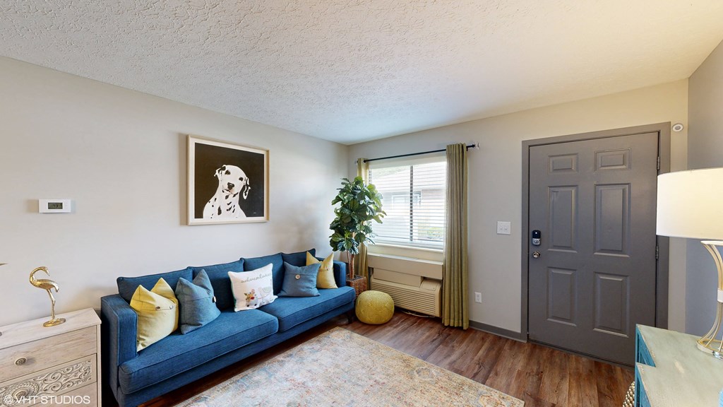 a living room with a blue couch and a grey door at Springburne at Polaris Apartments, Columbus, 43235