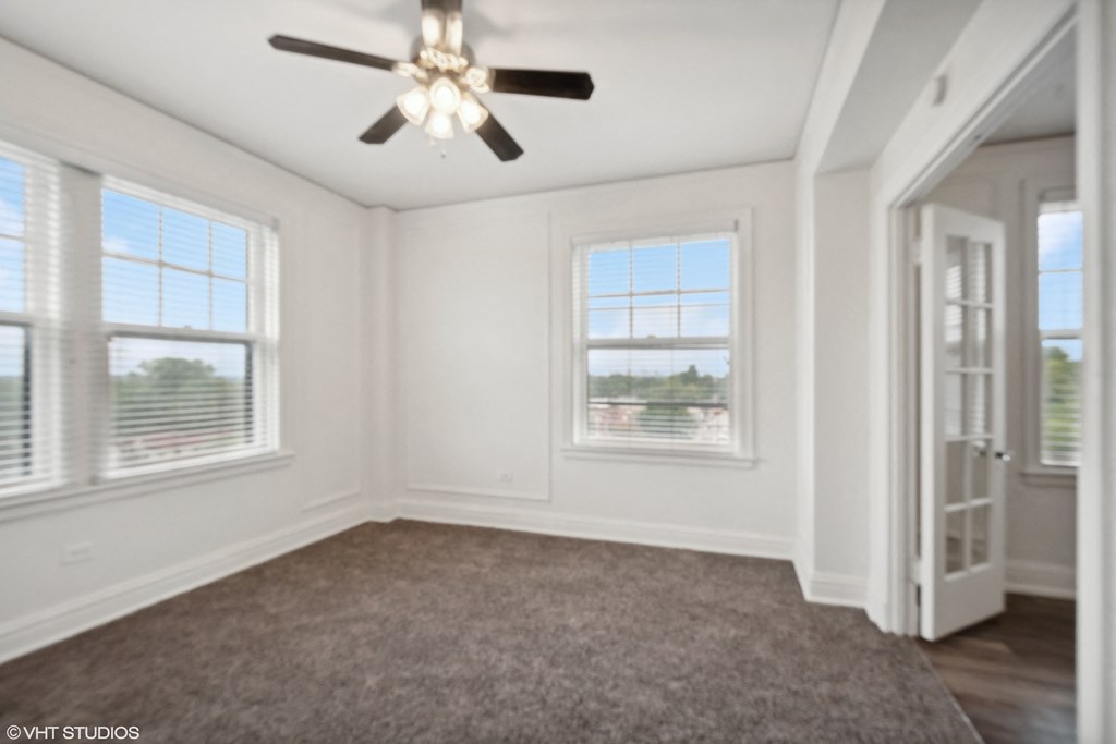 a living room with a carpet and a ceiling fan at CWE Apartments, St. Louis, MO, 63108