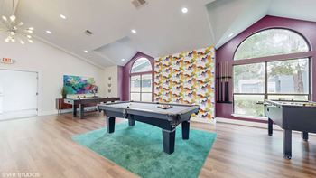 A room with a pool table and a foosball table.