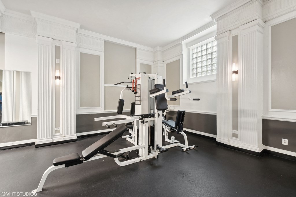 the gym has two treadmills and a row of white columns at CWE Apartments, St. Louis, Missouri