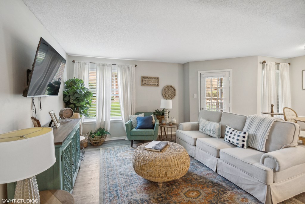 a living room with a couch and a chair and a tv at The Local Apartments, Memphis, TN, 38115