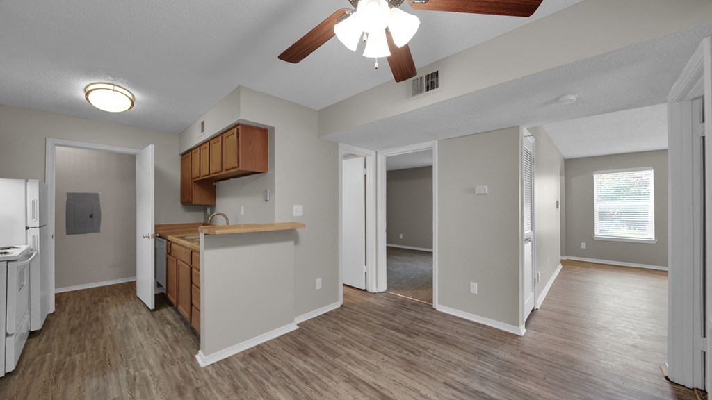 A room with a ceiling fan and a kitchenette. at The Local Apartments, Memphis