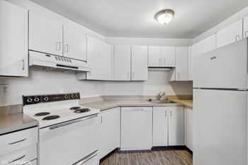 a white kitchen with white appliances and white cabinets at Delmar Loop Apartments, Missouri