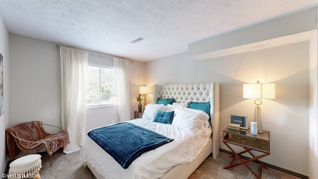a bedroom with a bed and a chair and a window a bedroom with a bed and a chair and a window at Runaway Bay Apartments, Columbus, Ohio