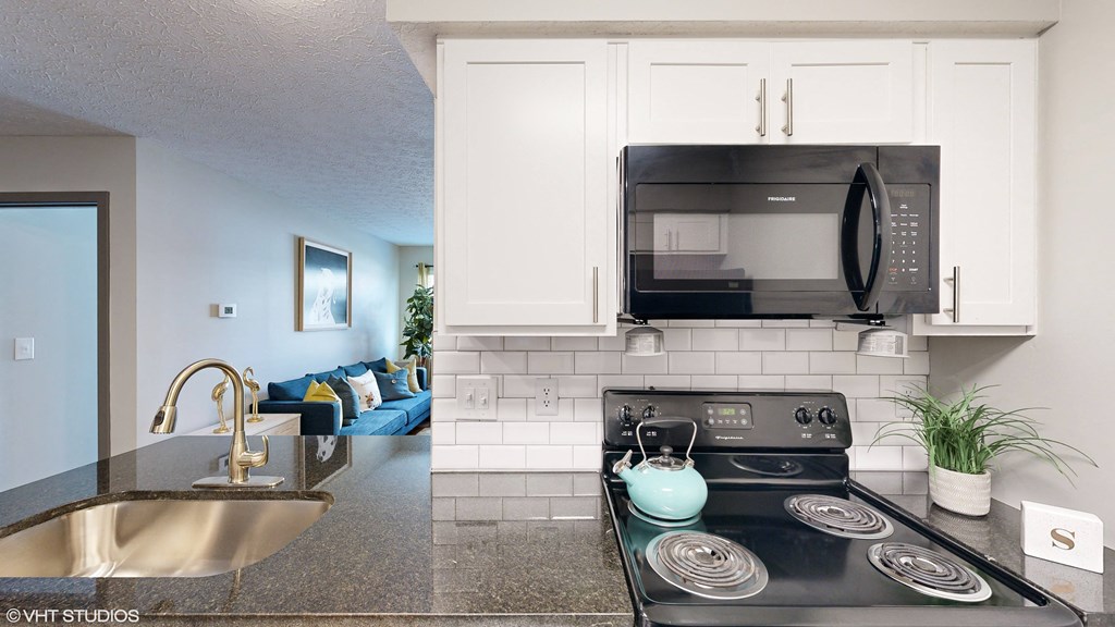 a kitchen with a stove and microwave and a sink at Springburne at Polaris Apartments, Columbus, OH