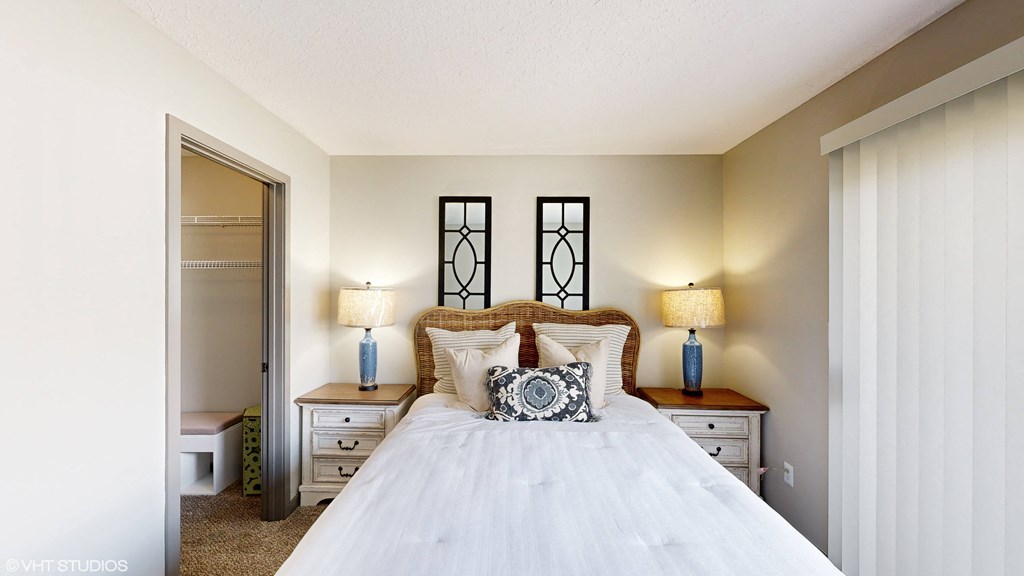 a bedroom with a bed and two lamps and a closet at Springburne at Polaris Apartments, Ohio, 43235