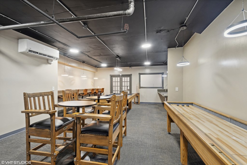 a dining room with wooden tables and chairs and a communal table at CWE Apartments, St. Louis, Missouri