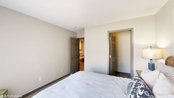 a bedroom with a large bed and a door to a bathroom