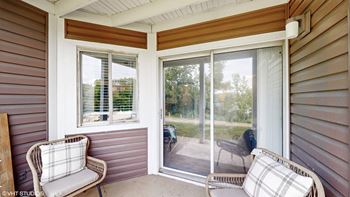 a porch with two chairs and a sliding glass door at Runaway Bay Apartments, Ohio