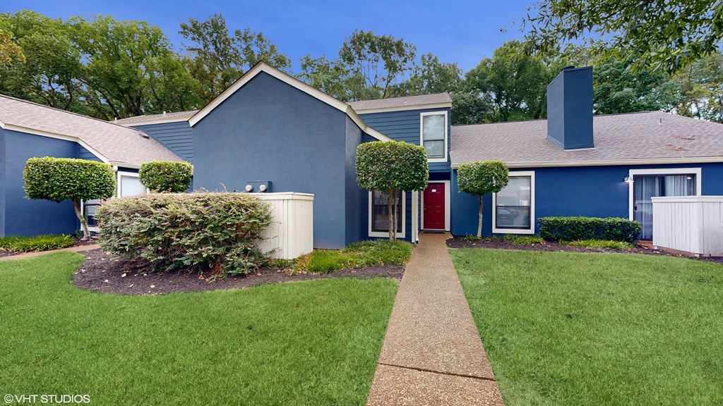 a blue house with a yard and a walkway at The Vale Apartments and Townhomes, Tennessee, 38018