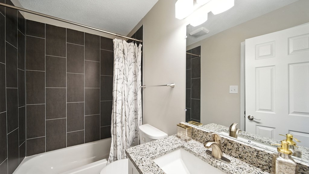 A bathroom with a white tub, sink, and shower curtain.
