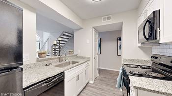 A kitchen with a stainless steel refrigerator and a stove top oven.