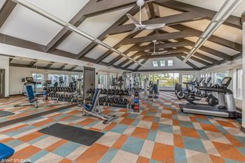 a gym with weights and cardio equipment in a building with windows at Runaway Bay Apartments, Columbus, Ohio