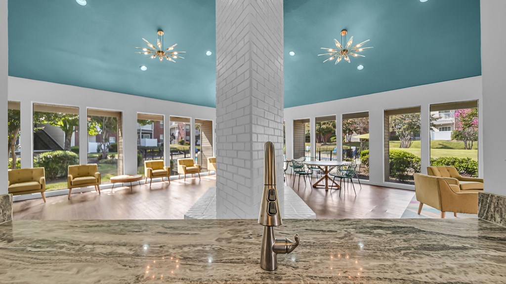 A lobby with a marble floor and a large column in the middle.