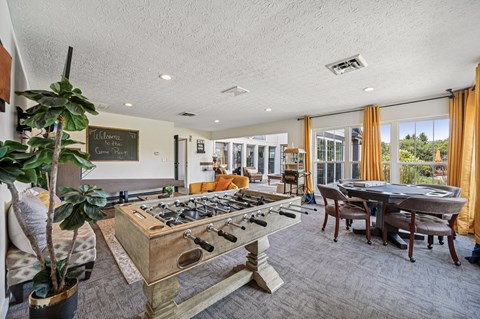 A room with a pool table and a chalkboard on the wall.