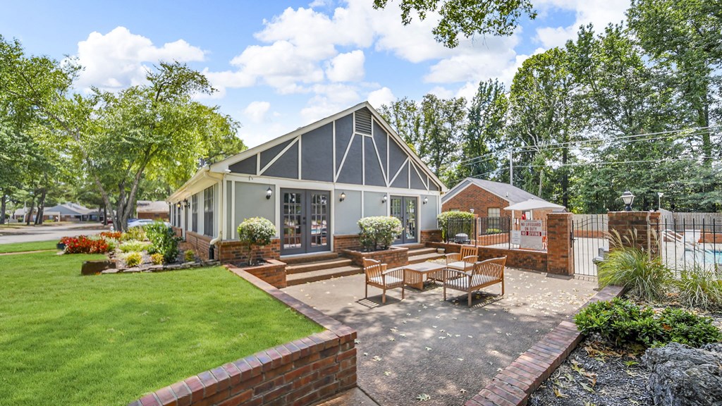 A modern house with a grey and white exterior and a red brick wall.