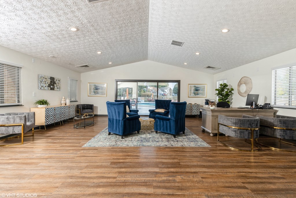 a living room with blue chairs and a large window at Springburne at Polaris Apartments, Columbus, Ohio