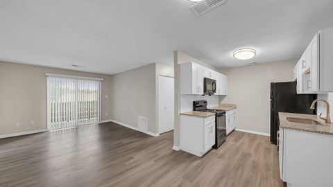 A kitchen with white cabinets and a black fridge. at The Stella Apartments, Memphis, Tennessee