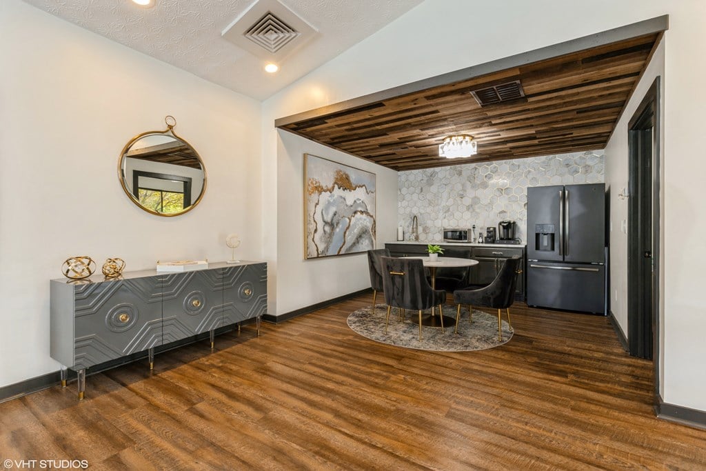 a kitchen and dining room with a black refrigerator and a table and chairs a kitchen and dining room with a black refrigerator and a table and chairs at Springburne at Polaris Apartments, Ohio