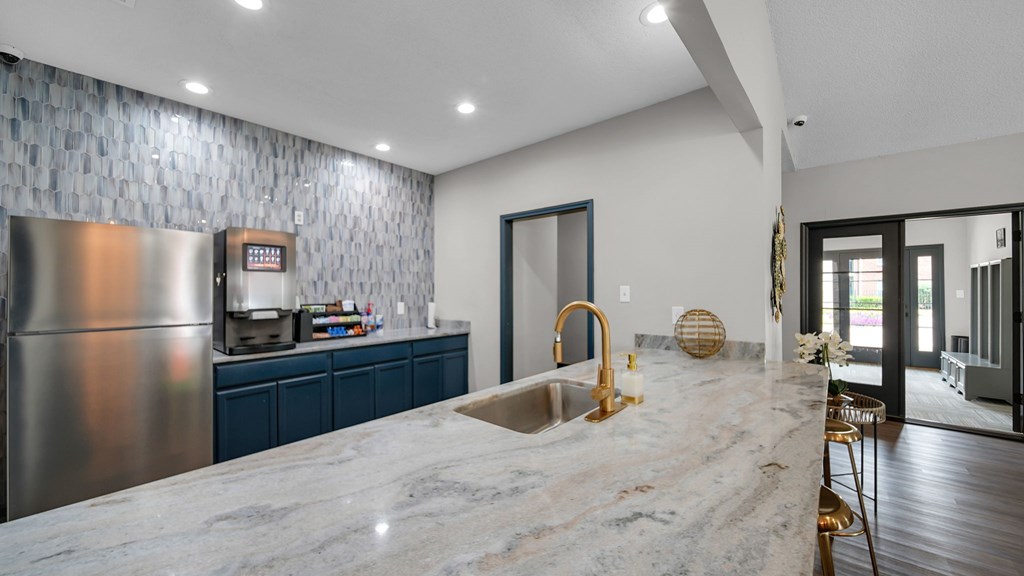A modern kitchen with a marble countertop and stainless steel appliances. at The District Apartments, Memphis, TN