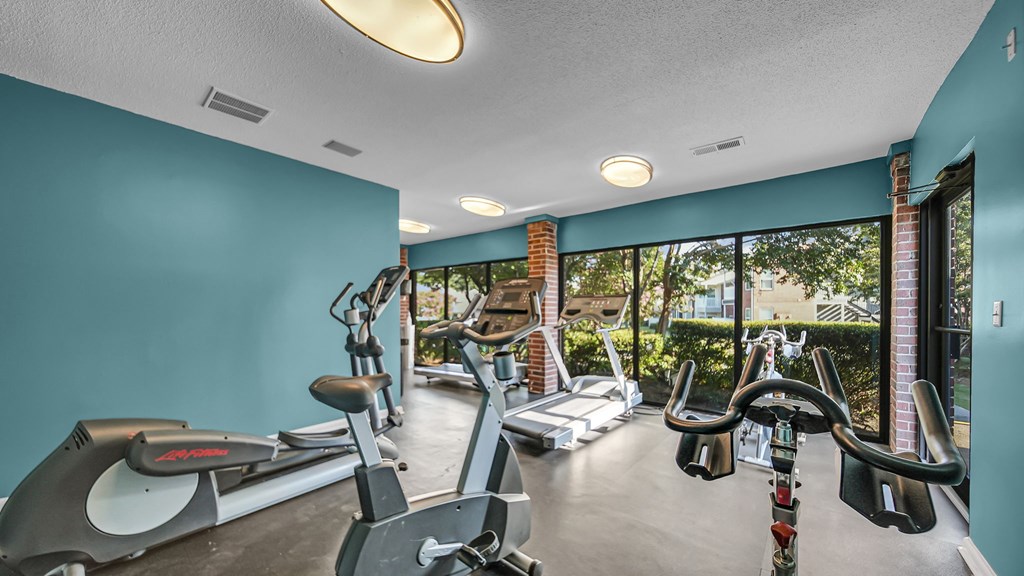 A gym with treadmills, exercise bikes, and elliptical machines.